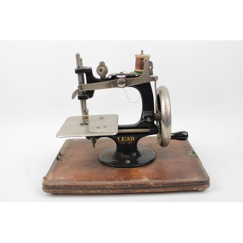 236 - Lead Machine German Childs sewing machine in Walnut domed case