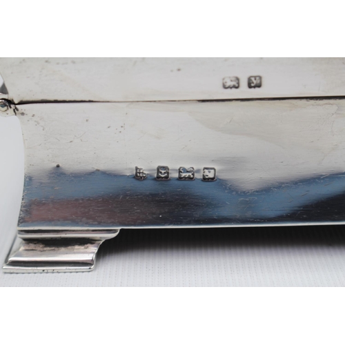 86 - Art Deco Silver cigarette box with concave shaped sides and bracket feet 14cm wide, Birmingham 1923.... 