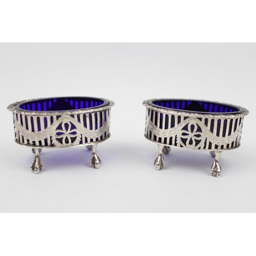 90 - Pair of Oval Silver open salts with blue glass liners, pierced wreath design over paw feet London 19... 