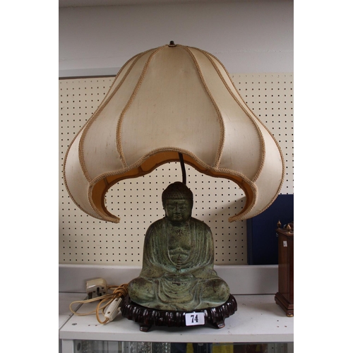 74 - Chinese Bronze Buddha in seated pose mounted lamp on plinth with shaped shade surmounted