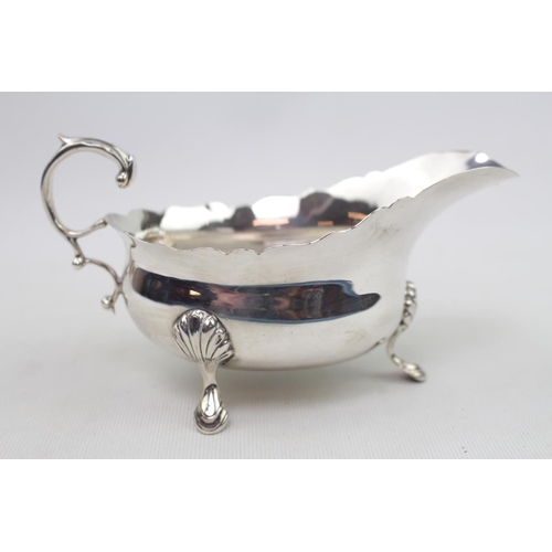 395 - George IV Silver Sauce boat supported on pad feet and scroll handle by H Pidduck & Sons London 1940.... 