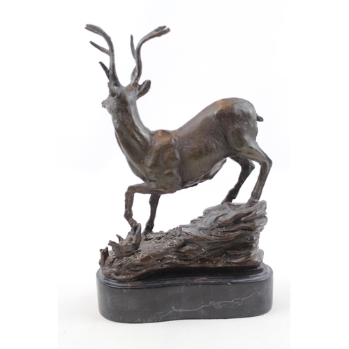 83 - Bronze of a Stag in naturalistic setting mounted on marble base. 25cm in Height