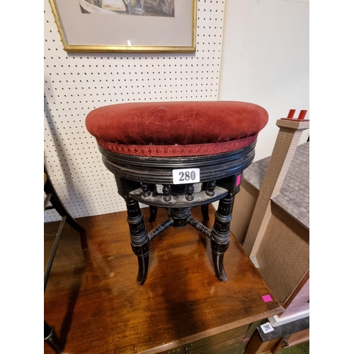 280 - Victorian revolving upholstered piano stool with upholstered top and ebonised base