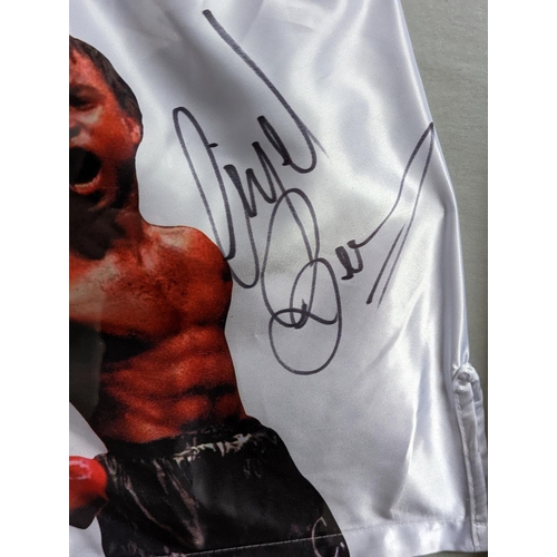 77 - Chris Eubank vs Nigel Benn signed shorts Framed. 86 x 83cm