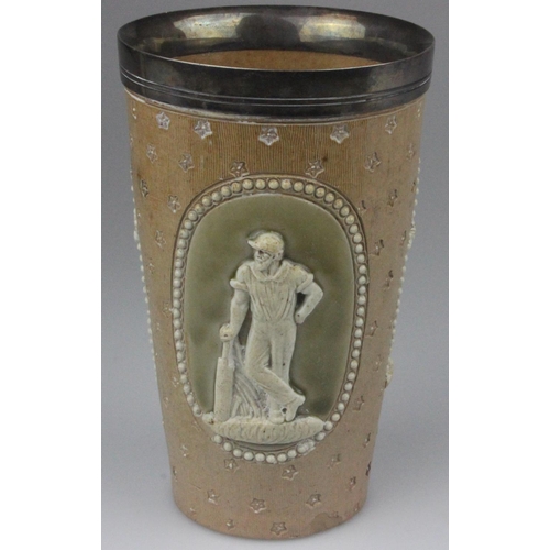 23 - A Royal Doulton Lambeth Ware cricket beaker with a silver plated rim. The three scenes are of cricke... 