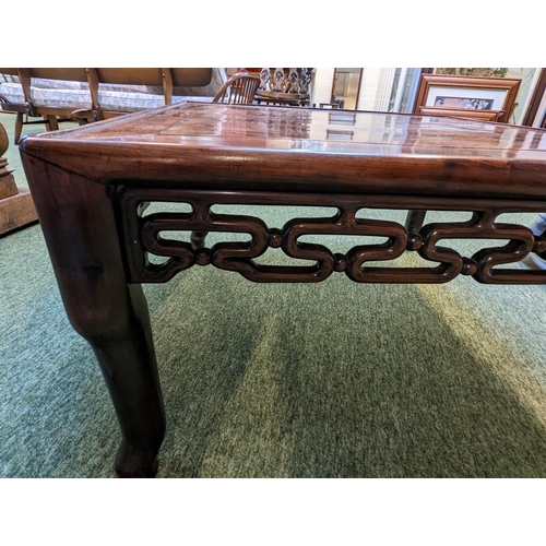 211 - A CHINESE HUANGHUALI LOW TABLE CIRCA 1900
The square top with inset plank panel over carved pierced ... 