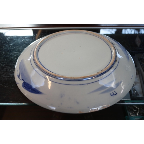 62 - Large Japanese blue and white charger decorated with rocky outcrop and Prunus tree. 37cm in Diameter