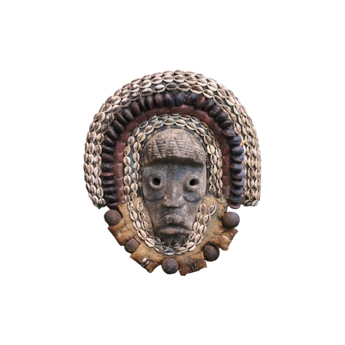 129 - African Tribal Mask decorated with Cowrie shells and Nuts possibly Western Africa. 45cm in Height