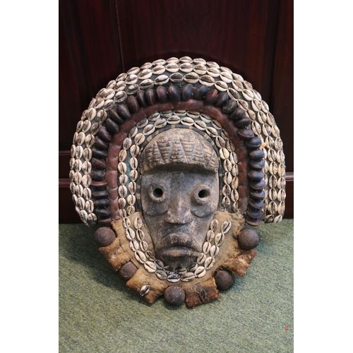 129 - African Tribal Mask decorated with Cowrie shells and Nuts possibly Western Africa. 45cm in Height