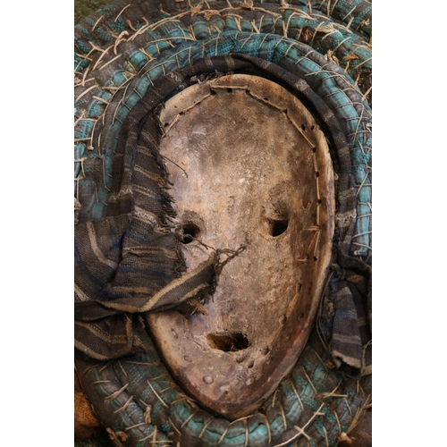 129 - African Tribal Mask decorated with Cowrie shells and Nuts possibly Western Africa. 45cm in Height