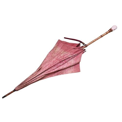 135 - A Vintage Kendall parasol, with White and Maroon floral decoration, the carved bone handle formed as... 