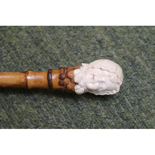 135 - A Vintage Kendall parasol, with White and Maroon floral decoration, the carved bone handle formed as... 