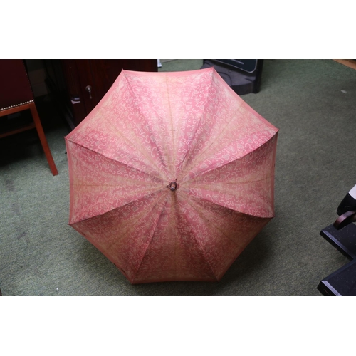 135 - A Vintage Kendall parasol, with White and Maroon floral decoration, the carved bone handle formed as... 