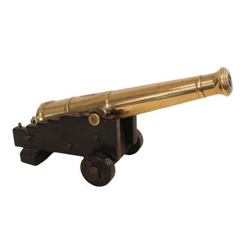 174 - A 19th Century Small Desk Signal Cannon on an oak carriage with two solid wheels, 27cm in Length