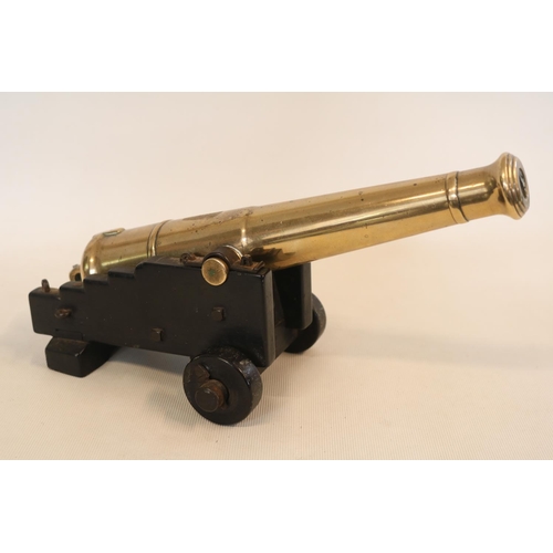 174 - A 19th Century Small Desk Signal Cannon on an oak carriage with two solid wheels, 27cm in Length