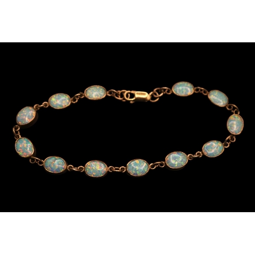 370 - Ladies 9ct Gold Oval Opal set Bracelet. Twelve 9mm Oval Rub over set Opals with Lobster clasp. 21cm ... 