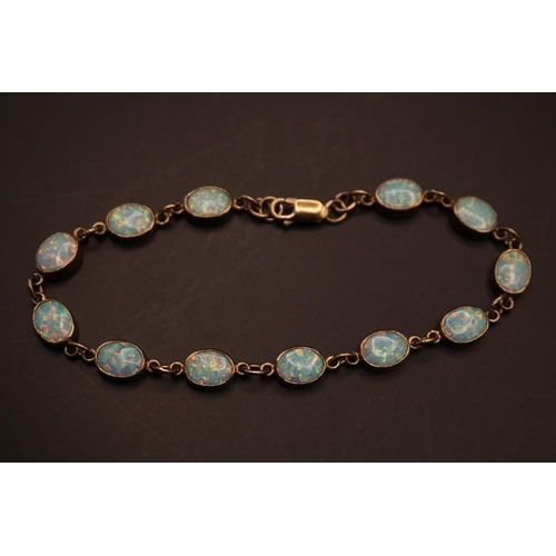 370 - Ladies 9ct Gold Oval Opal set Bracelet. Twelve 9mm Oval Rub over set Opals with Lobster clasp. 21cm ... 