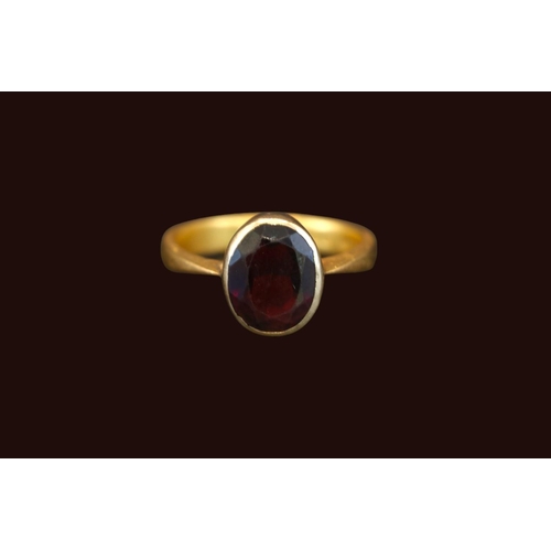 389 - 22ct Gold Rub over set Oval Almandine Garnet 2.9ct estimated weight. Size Q. 5.8g total weight