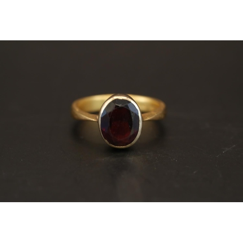 389 - 22ct Gold Rub over set Oval Almandine Garnet 2.9ct estimated weight. Size Q. 5.8g total weight