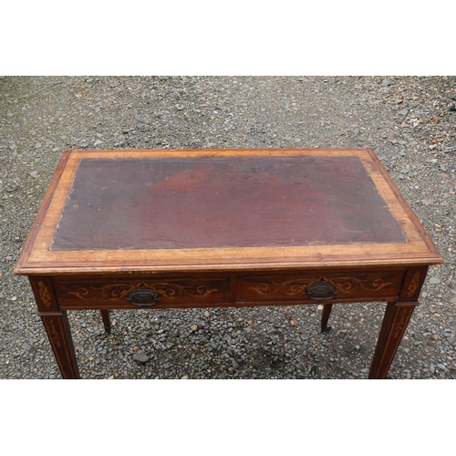 424 - Edwardian Rosewood veneered two drawer desk on tapering legs and brass caster feet. 89cm in Width