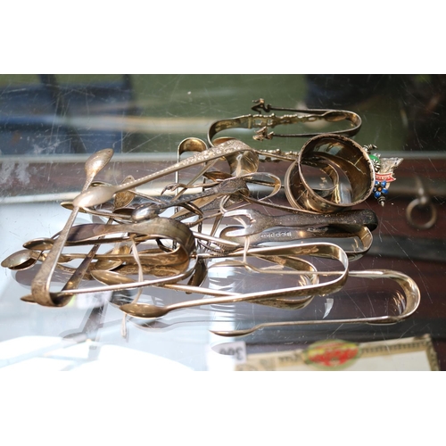 390 - Large collection of Silver Sugar Tongs and a Silver Napkin Ring 320g total weight