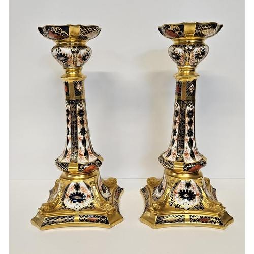 15 - A Pair of Royal Crown Derby Table Candlesticks, on square dolphin bases, decorated in Imari pattern ... 