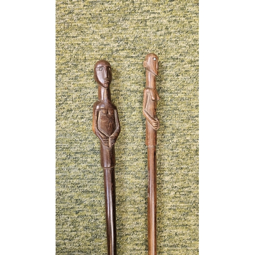 53 - 2 South African Hardwood walking canes the handle carved with a mans head and torso (L 89cm) and sim... 