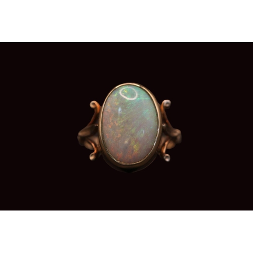 186 - Ladies 9ct Gold Oval Opal ring, set with Opal measuring 16mm x 11mm within rub over setting and fleu... 