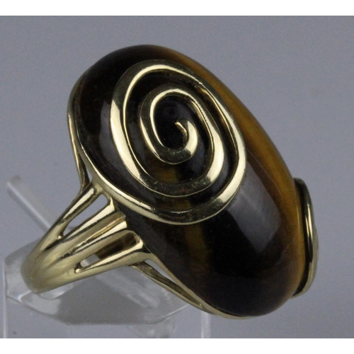 221 - 9ct gold dress ring, set with a large oval cabochon tigers eye stone, measuring approximately 28mm x... 