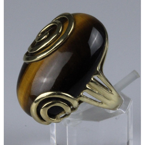 221 - 9ct gold dress ring, set with a large oval cabochon tigers eye stone, measuring approximately 28mm x... 