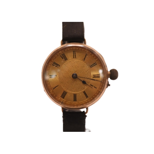 236 - Ladies 9ct Gold Edwardian wristwatch with numeral dial on black fabric strap. 32mm in Diameter