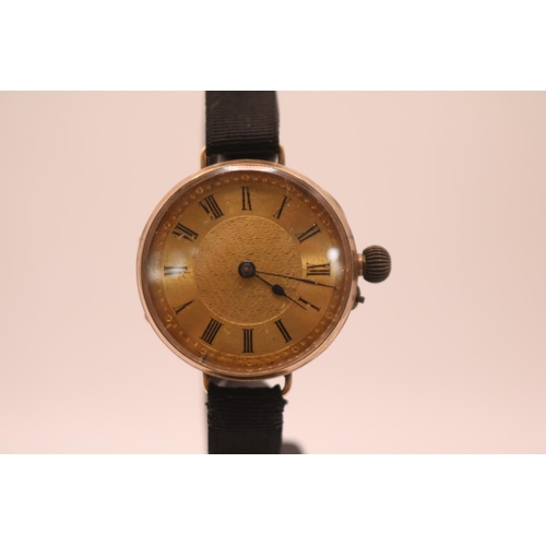 236 - Ladies 9ct Gold Edwardian wristwatch with numeral dial on black fabric strap. 32mm in Diameter