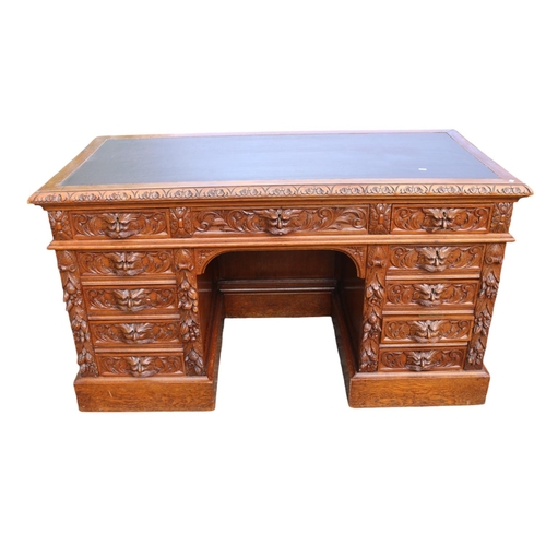 364 - 19thC Oak Heavily carved Greenman pedestal desk with Eleven drawers, carved panel sides and front an... 