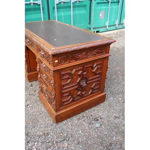 364 - 19thC Oak Heavily carved Greenman pedestal desk with Eleven drawers, carved panel sides and front an... 