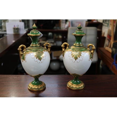 114 - Pair of Royal Worcester lidded vases with landscape panels gilt handles model 2160 Rd No 374254. 25c... 