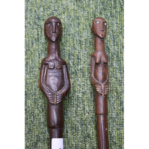 58 - 2 South African Hardwood walking canes the handle carved with a mans head and torso (L 89cm) and sim... 