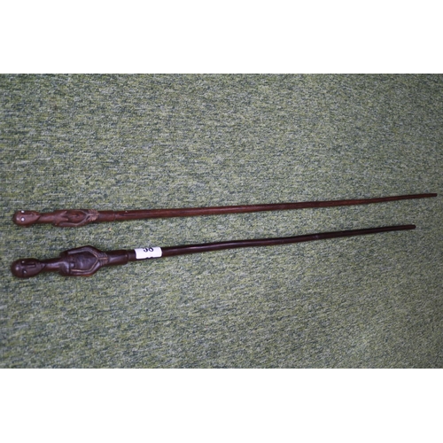 58 - 2 South African Hardwood walking canes the handle carved with a mans head and torso (L 89cm) and sim... 