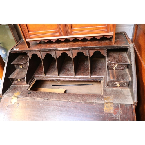 553 - Late 19thC Oak Heavily carved fall front bureau with brass drop handles over bracket feet