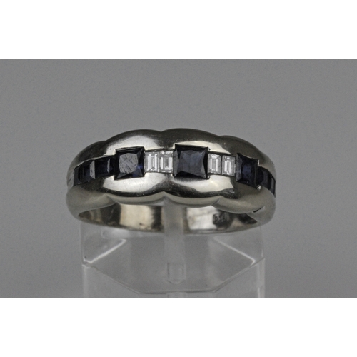 18ct Gold, Sapphires & Diamonds Ring. 18ct gold ring with 9 square cut blue sapphires, the largest 3 approximately 0.25 carats each stone & 4 baguette cut brilliant diamonds. Weighs 5.2gms. Ring size O.