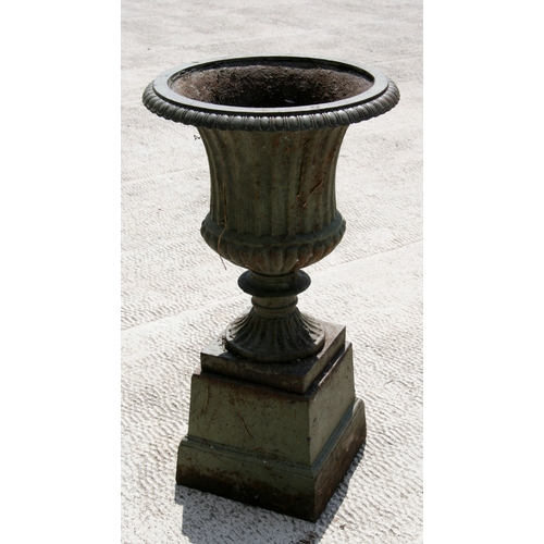 7 - A cast iron campana shaped urn on stand. 68cm (26.75 ins) high