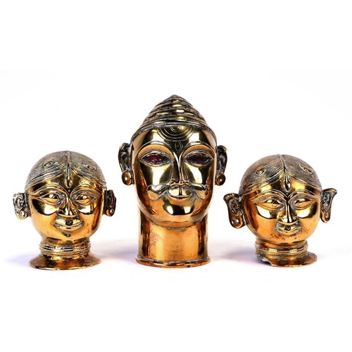 307 - A group of three probably 19th century Indian polished bronze deity heads, the largest 20cms (8ins) ... 