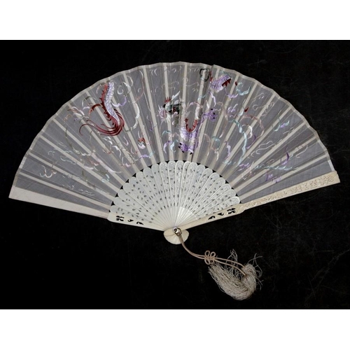 315 - A Chinese carved and pierced ivory fan with silk embroidered dragon, fitted in a black lacquer box.