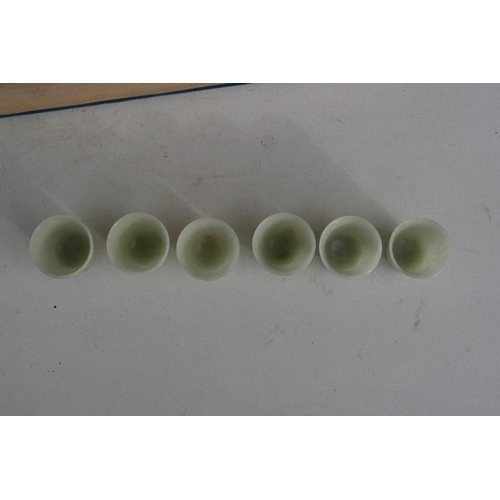 328 - A cased set of twelve Chinese jade like cups with D & S Howlett collection label to the undersid... 