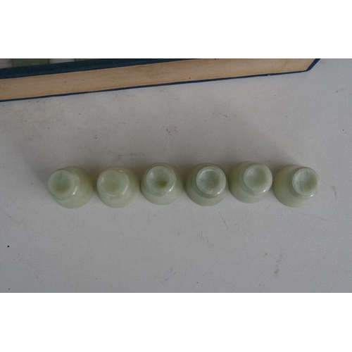 328 - A cased set of twelve Chinese jade like cups with D & S Howlett collection label to the undersid... 