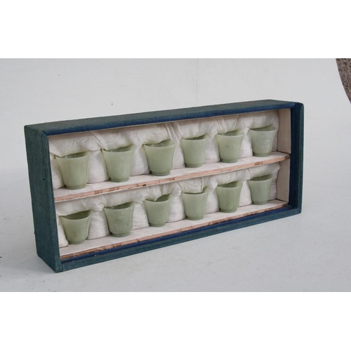 328 - A cased set of twelve Chinese jade like cups with D & S Howlett collection label to the undersid... 