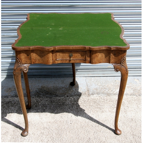 653 - A George II style walnut fold-over card table retailed by Harrods, 81cm (32 ins) wide.