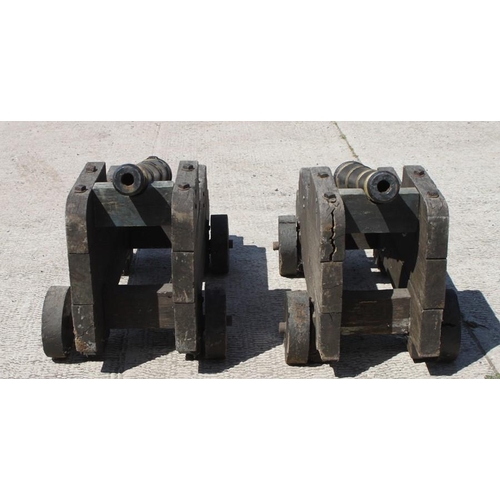 294 - A pair of 19th century solid oak Cannon carriages on oak wheels (slightly modified to hold two ornam... 