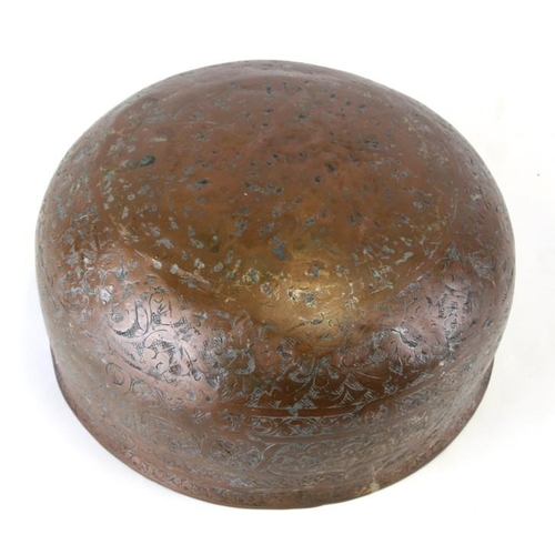 325 - An early Persian copper bowl decorated with foliate scrolls and script, 24cms (9.5ins) diameter.