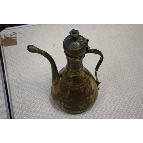 323 - A Turkish gilt copper coffee pot or ewer, 23cms (9ins) high.