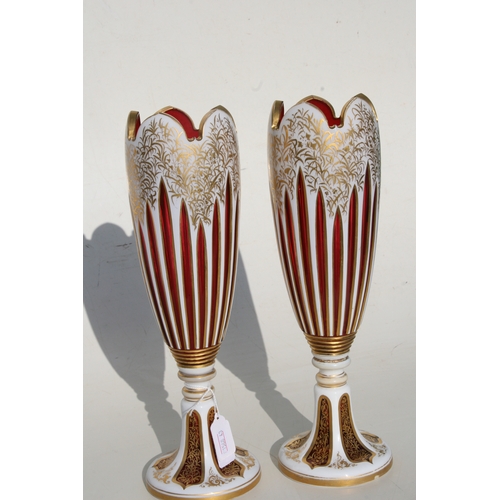 36 - A fine pair of 19th century Bohemian cranberry glass overlaid vases with gilt decoration, 31cms (12.... 